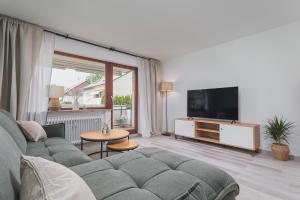 een woonkamer met een bank en een flatscreen-tv bij Traumhaftes Apartment mit Balkon und Parkplatz in Waiblingen