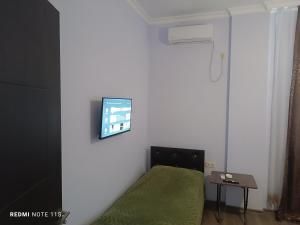 a bedroom with a bed and a tv on a wall at Guest House Irakli in Makhinjauri