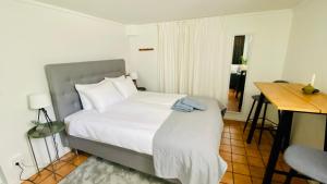 a bedroom with a bed and a table and a desk at Sundsvall By M - Basement Studio in Sundsvall +11 photos