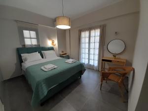 a bedroom with a green bed with a mirror and a chair at Villa Emily in Syvota