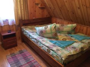 - une chambre avec un lit dans une cabane en rondins dans l'établissement У Сергія, à Lumshory