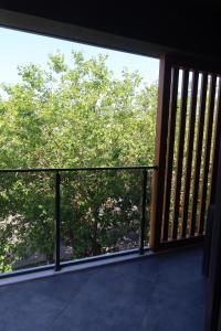 a balcony with a view of a tree at MAYA APARTMANI in Kuşadası