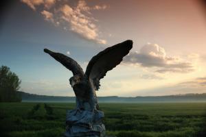 a statue of an eagle statue in a field at Café & Pension Goldbachmühle in Blankenburg