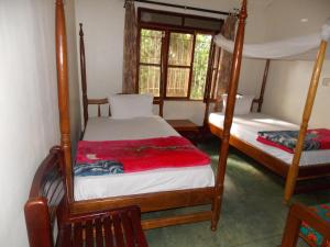 una camera con 2 letti a castello e una finestra di Botanical Skyway Inn Entebbe a Entebbe