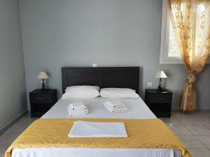 a bedroom with a large bed with two towels on it at Galini Rooms Sikinos Travel in Sikinos