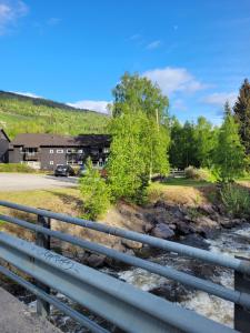 a bridge over a river with a building in the background at Friends & Family Apartment at Hafjell Alpinlandsby/Øyer Center in Hafjell