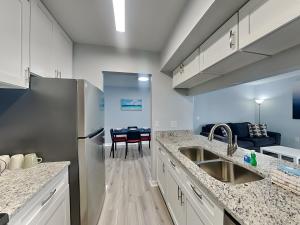 a kitchen with a refrigerator and a dining room at Madeira Beach Yacht Club 261f in St. Pete Beach