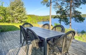 a table and chairs on a deck next to a lake at Beautiful Home In Aplared With 2 Bedrooms, Sauna And Wifi in Aplared