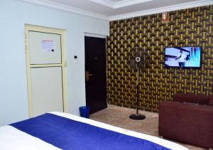 a bedroom with a bed and a tv on a wall at 1 Bedroom Short Let Apartment-Hotel Penthouse in Lekki