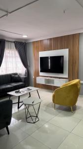 sala de estar con sofá y TV en Two bedroom apartment in ikeja, en Ikeja