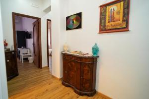 a room with a wooden cabinet and a painting on the wall at Casa Mercy in Catania