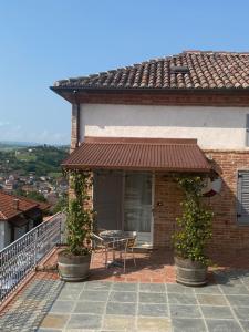 un balcone di una casa con tavolo e sedie di La terrazza sul Monferrato a Montegrosso dʼAsti