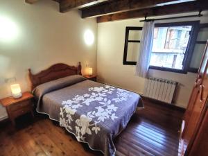 a bedroom with a bed and a window at Casa Rural con patio y BBQ en La Vall de Boí in Cardet