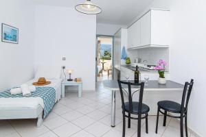a kitchen and living room with a bed and a table at Sunshine Garden Apts in Malia