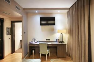 Habitación con escritorio con lámpara y silla. en Hotel & Spa Villa Mercede, en Frascati