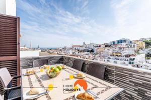 a balcony with a table with food and a view of the city at #164 Saradel 42 by Home Holidays in Albufeira