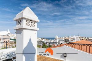 a white clock tower on the roof of a building at #164 Saradel 42 by Home Holidays in Albufeira
