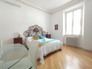 Dormitorio blanco con cama y mesa de cristal en AMAMARE en Marina di Pisa