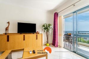 un soggiorno con TV e ampia finestra di #166 Old Town, 600 mts Beach with Pool ad Albufeira