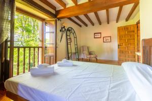ein Schlafzimmer mit einem Bett und einem großen Fenster in der Unterkunft Secret Retreat by Fidalsa in Entrambasaguas