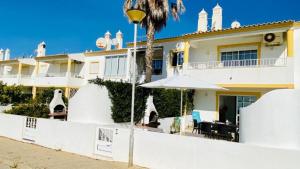 a house with a palm tree in front of it at Sao Rafael Beach Flat in Albufeira