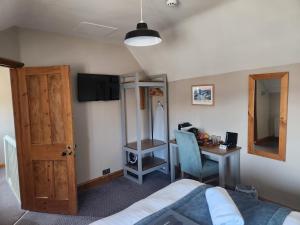 1 dormitorio con cama, escritorio y mesa en The Station Inn Whitby, en Whitby