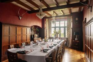 a long dining room with a long table with chairs at Christie Mansion - Luxury Cottages in Shanklin