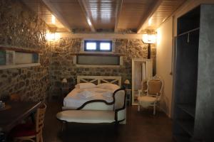 um quarto com uma cama, 2 cadeiras e uma janela em FARMAHOUSE em Orchomenós