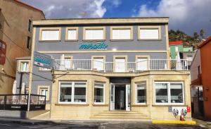 Un edificio con un cartel al costado. en Hospedium Morada da Moa, en O Pindo