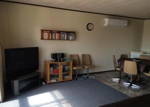 a living room with a tv and a table and chairs at All Decked Out in Edithburgh in Edithburgh