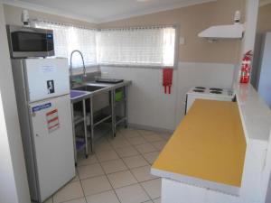 a small kitchen with a refrigerator and a sink at Seachange in Brentwood