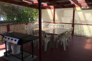 a table and chairs on a deck with a grill at All Decked Out in Edithburgh in Edithburgh