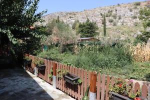 een tuin met een hek en een aantal planten bij FARMAHOUSE in Orchomenós