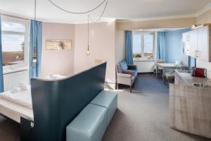 um quarto de hospital com uma cama e uma cozinha em Inselhotel Langeoog em Langeoog