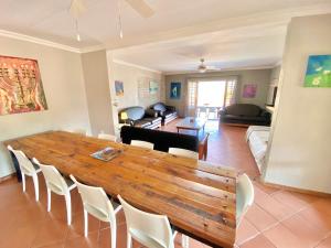 een woonkamer met een grote houten tafel en stoelen bij Selah Guest Cottages Self-catering Farmstay Accommodation in Nelspruit