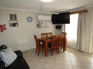 a dining room with a table and chairs and a television at Clan Ranald Holiday Unit 1 in Edithburgh
