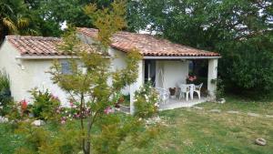 a small white house with a table and chairs at Les Deux Riviéres in Les Touches-de-Périgny +3 photos
