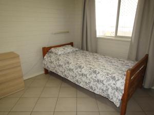 a small bedroom with a bed and a window at Clan Ranald Holiday Unit 1 in Edithburgh
