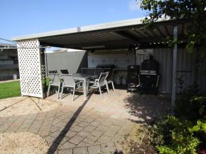 a patio with a table and chairs under awning at Clan Ranald Holiday Unit 1 in Edithburgh