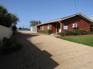 a driveway leading to a red brick house at Clan Ranald Holiday Unit 1 in Edithburgh