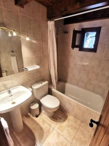a bathroom with a sink and a toilet and a bath tub at Tríplex con patio y BBQ en La Vall de Boí in Cardet
