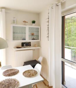 a white dining room with a white table and chairs at Apartament Morze Sztuki, Jantar in Jantar