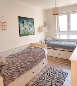- une chambre avec 2 lits et un tableau mural dans l'établissement Apartament Morze Sztuki, Jantar, à Jantar