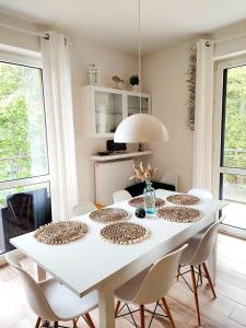 a white dining room with a white table and chairs at Apartament Morze Sztuki, Jantar in Jantar