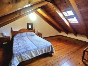 a bedroom with a bed and a wooden floor at Tríplex con patio y BBQ en La Vall de Boí in Cardet