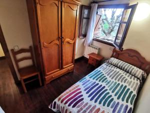 a bedroom with a bed and a dresser and a window at Tríplex con patio y BBQ en La Vall de Boí in Cardet