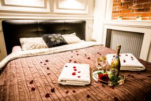 a bed with a bottle of champagne and a plate of food at Luxury Jacuzzi Apartment in Kraków