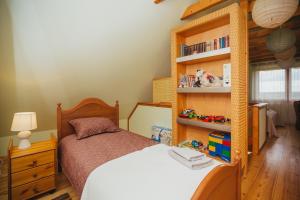 een slaapkamer met een bed en een boekenplank bij Mājiņa ar pirti ,lauku apvidū. 