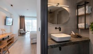 a bathroom with a sink and a mirror at Alea Suites -Adults Only and Kids 14 Plus in Asprovalta +45 photos