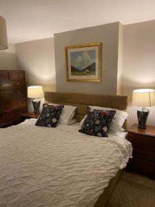 a bedroom with a bed with two pillows and two lamps at Ballea Farmhouse in Cork